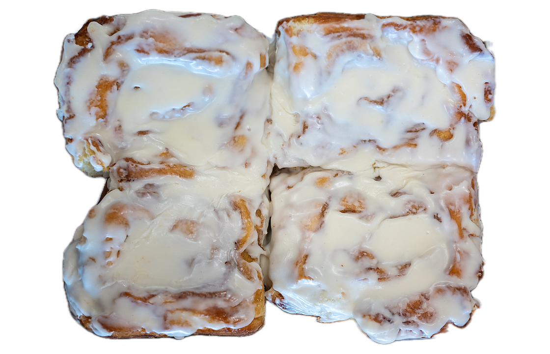 Four cinnamon buns topped with white icing